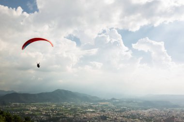 şehirde mavi gökyüzü üzerinde renkli yamaç paraşütü