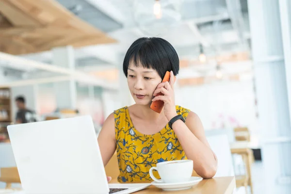 Donna ascoltare al telefono cellulare e al lavoro — Foto Stock