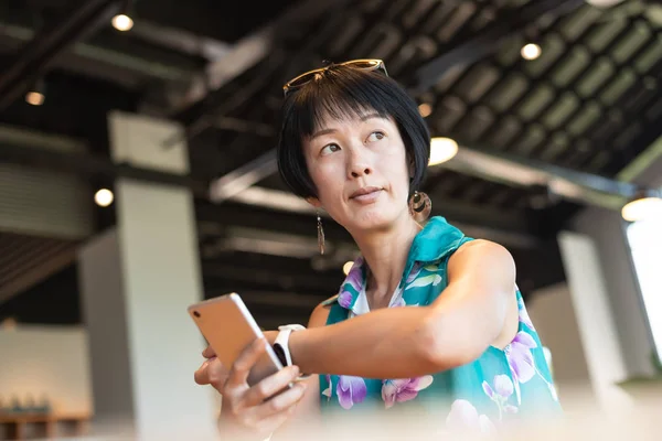 Жінка використовує смартфон з розумним годинником — стокове фото
