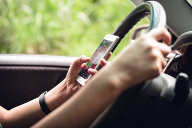 arabada akıllı telefon kullanan kadın