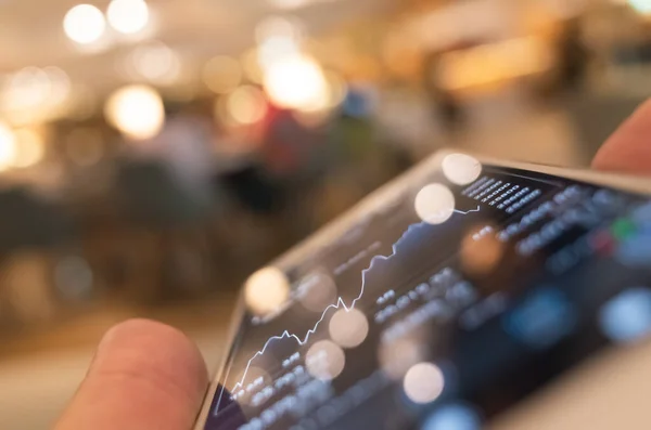 Utilizar un dispositivo móvil para comprobar los datos del mercado — Foto de Stock