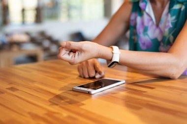 Akıllı saati olan akıllı telefon kullanan kadın.