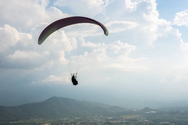 şehirde mavi gökyüzü üzerinde renkli yamaç paraşütü