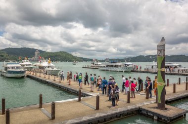 Xuanguang tapınak iskelesinde turistler ve tekneler