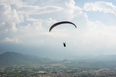 şehirde mavi gökyüzü üzerinde renkli yamaç paraşütü