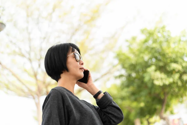 Азиатка разговаривает по телефону — стоковое фото