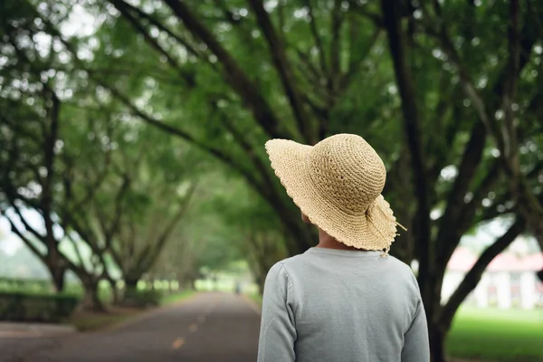 Donna fare una passeggiata sulla strada sotto gli alberi — Foto Stock