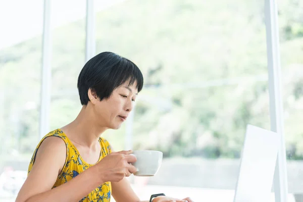 Азиатка работает и использует ноутбук — стоковое фото
