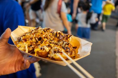 Kadınlar Tayvan, Asya 'da bir gece pazarında meşhur Tayvan ahtapot topları yerler.