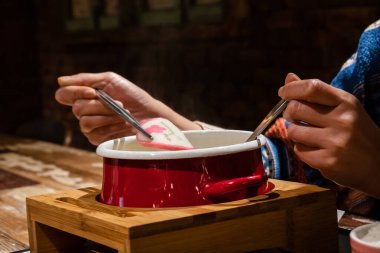 Sebzeli ve domuzlu sıcak tencere yiyen kadının yakın plan görüntüsü.