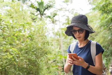 Yürüyüş yaparken cep telefonu kullanan bir kadın.