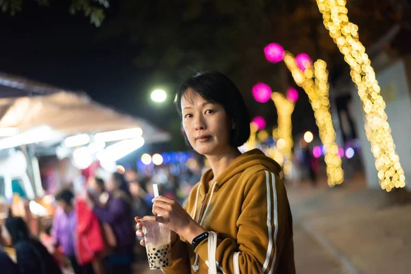 亚洲女人在夜市端着著名的泰国泡泡奶茶 — 图库照片