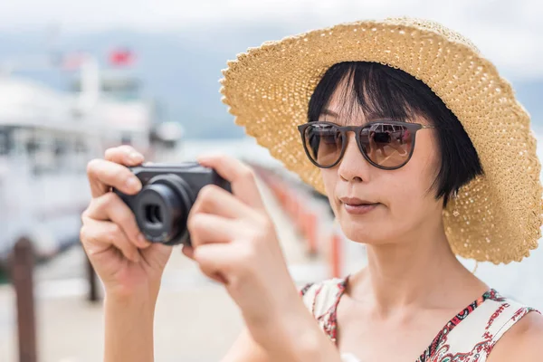 帽子をかぶったアジアの女性が台湾の日月潭で写真を撮る — ストック写真