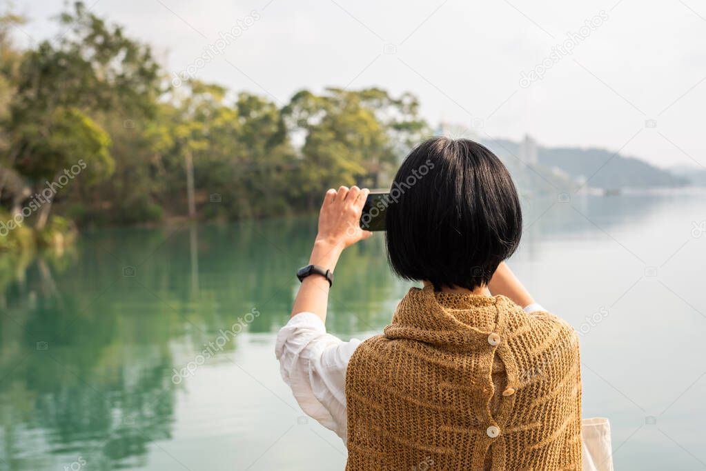 traveling woman take a picture near Sun Moon Lake, Nantou, Taiwan
