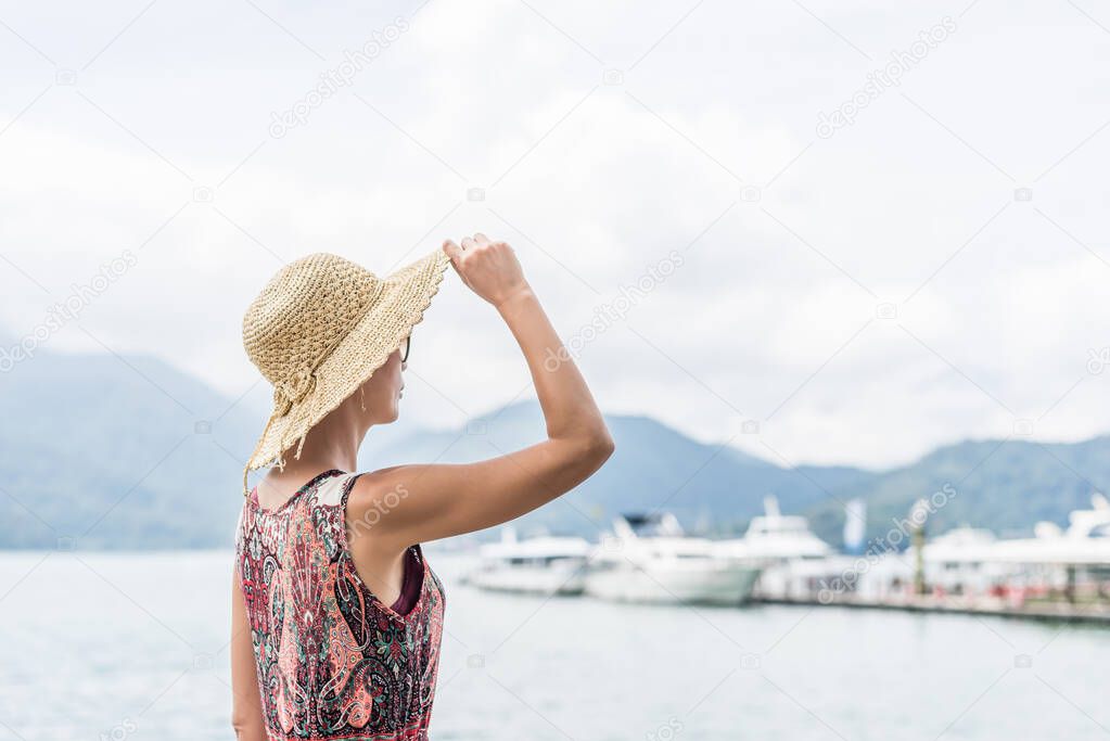 traveling Asian woman with hat standing at Sun Moon Lake, Taiwan
