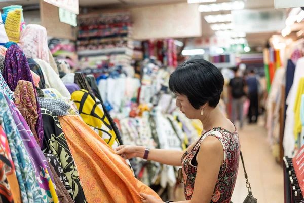 woman pick a roll of cloth at the fabric mall, Yongle market, Taipei, Taiwan, Asia