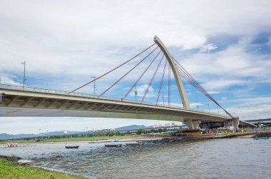 Taipei, Tayvan - 9 Haziran 2019: Taipei, Tayvan, Asya 'da düzenlenen geleneksel Ejderha Teknesi Festivali' nde köprü altında yarışan rekabetçi tekne manzarası