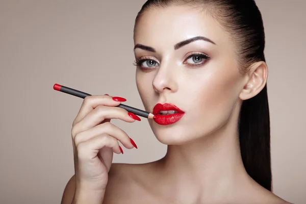 Piękna kobieta maluje usta szminką — Zdjęcie stockowe