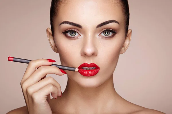 Belle femme peint les lèvres avec du rouge à lèvres — Photo