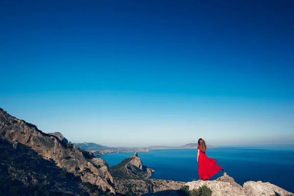 Mujer en vestido rojo por mar — Foto de Stock