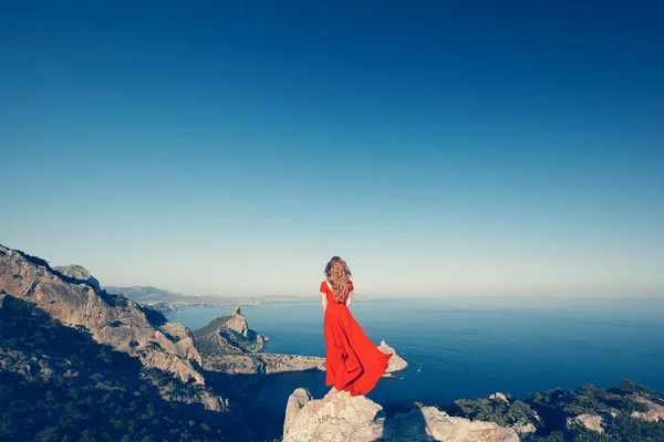 Mujer en vestido rojo por mar — Foto de Stock