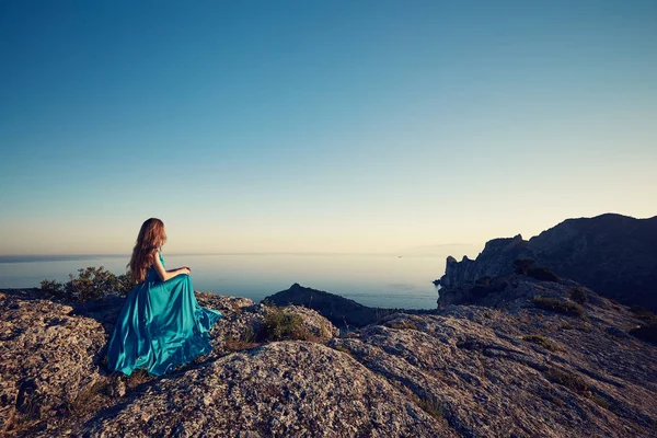 Mujer en vestido azul por mar — Foto de Stock