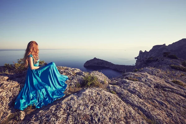 Mujer en vestido azul por mar — Foto de Stock