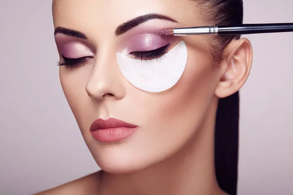 Make-up artiest geldt oogschaduw — Stockfoto