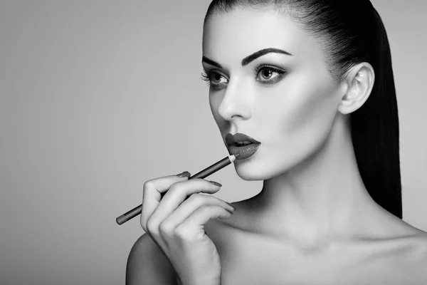 Foto en blanco y negro de la mujer pintando lápiz labial — Foto de Stock