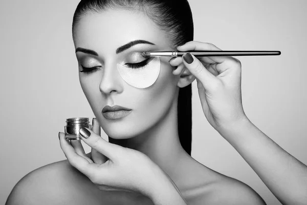 Svartvitt foto makeupartist applicerar ögonskugga — Stockfoto
