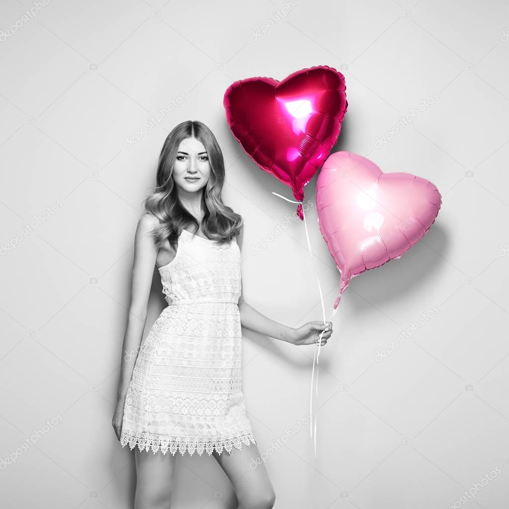 Beautiful young woman with heart shape air balloon