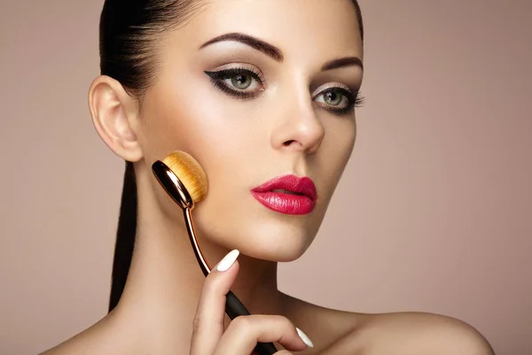 Maquillaje artista aplica skintone con cepillo —  Fotos de Stock