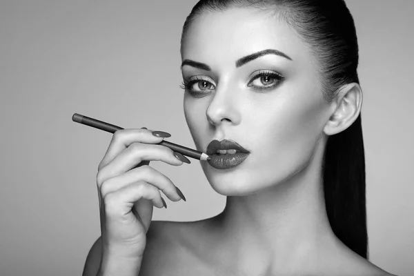 Beautiful woman paints lips with lipstick — Stock Photo, Image