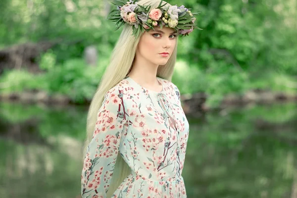 Belle femme blonde avec une couronne de fleurs sur la tête — Photo