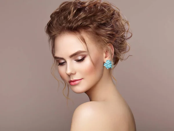 Fashion portrait of young beautiful woman with elegant hairstyle