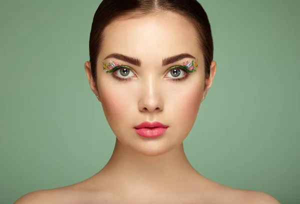 Молодая красивая женщина с цветочным макияжем глаза — стоковое фото