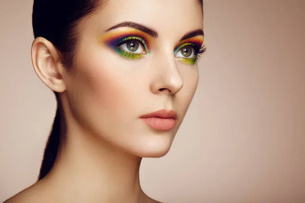 Portret van mooie jonge vrouw met regenboog make-up — Stockfoto