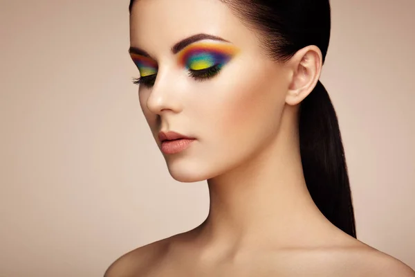 Porträt einer schönen jungen Frau mit Regenbogen-Make-up — Stockfoto