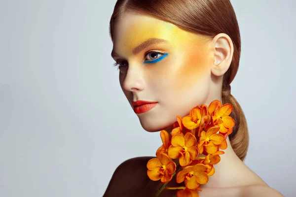 Portrait of beautiful young woman with orchid — Stock Photo, Image