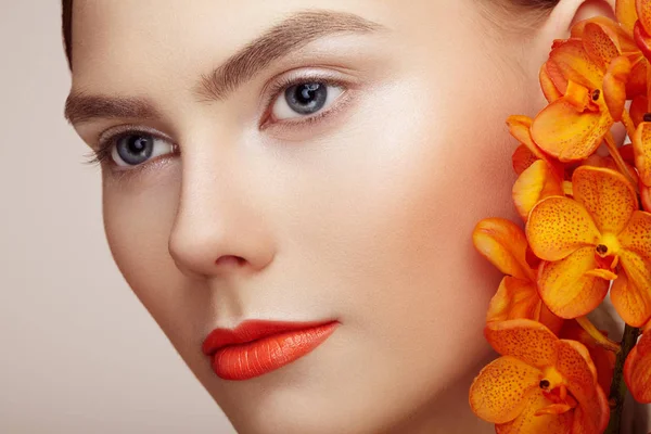 Retrato de bela jovem com orquídea — Fotografia de Stock