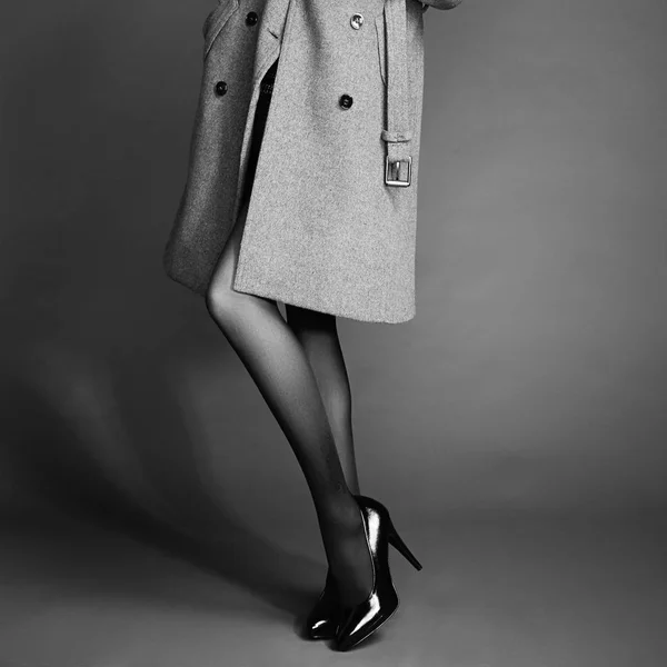 Молодая женщина в пальто с красивыми ногами — стоковое фото