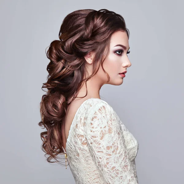 Brünette Frau mit langen und glänzenden lockigen Haaren — Stockfoto