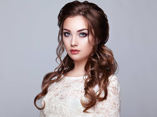 Брюнетка с длинными и блестящими вьющимися волосами
