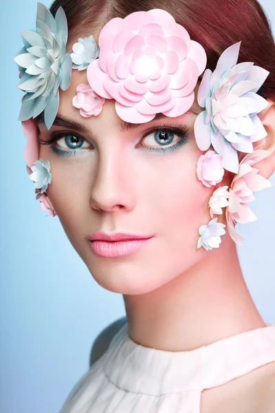 Gezicht van mooie vrouw versierd met bloemen — Stockfoto