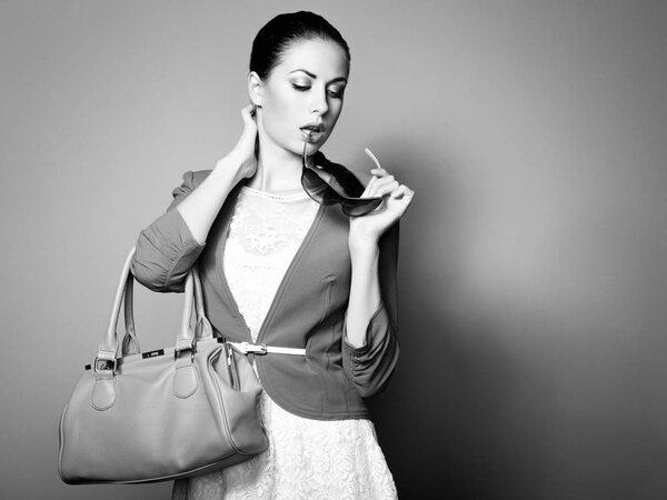 Portrait of beautiful young woman with a leather bag