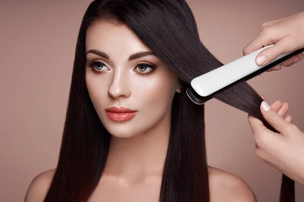 Cabeleireiro alisamento cabelo longo com ferros de cabelo — Fotografia de Stock