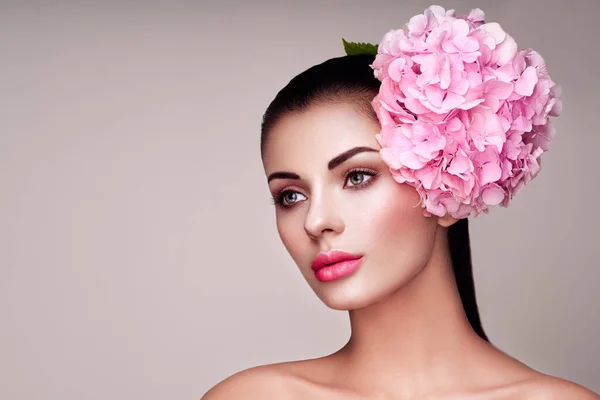 Portrait of beautiful young woman with flowers — Stock Photo, Image