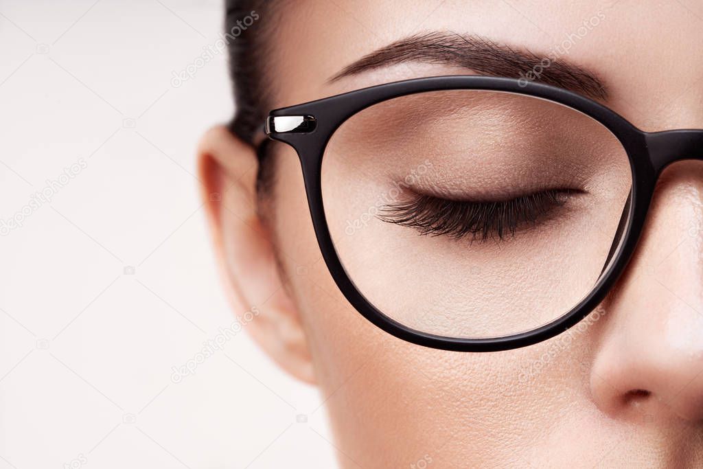 Female eye with long eyelashes in eyeglasses