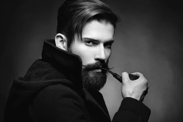 Brutal homme avec une barbe Fumer une pipe — Photo