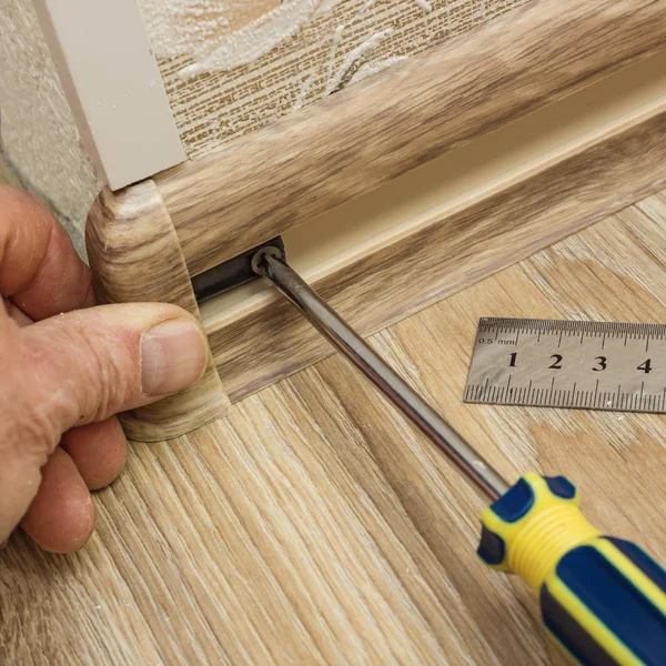 Builder assembles plinth at corner of room — Stock Photo, Image